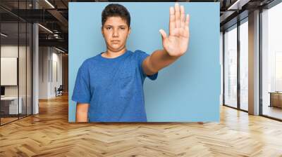 Teenager hispanic boy wearing casual clothes doing stop sing with palm of the hand. warning expression with negative and serious gesture on the face. Wall mural