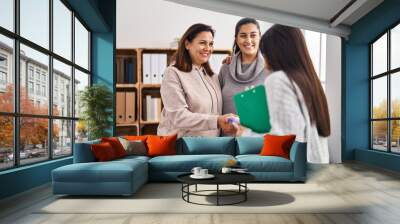 Three woman patient and psychologist shake hands at psychology center Wall mural