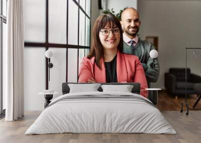 Two hispanic business workers smiling happy with arms crossed gesture standing at the office. Wall mural