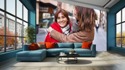 Two women mother and daughter hugging each other at street Wall mural