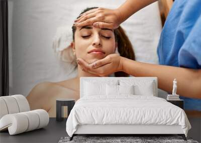 Two women therapist and patient having facial massage session at beauty center Wall mural