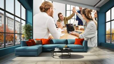 Two workers smiling happy high five during meeting at the office. Wall mural