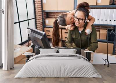 Woman and girl ecommerce call center agent working with her daughter at office Wall mural