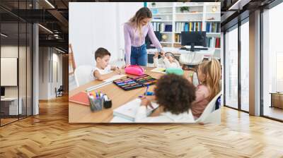 Woman and group of kids having lesson sitting on table at classroom Wall mural