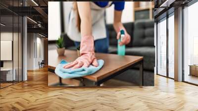 Woman cleaning table using rag and diffuser at home. Wall mural