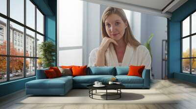 Woman enjoying tranquility in a spa wearing a white bathrobe in a serene wellness room Wall mural