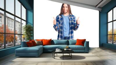 Young adult man with long hair wearing casual shirt success sign doing positive gesture with hand, thumbs up smiling and happy. cheerful expression and winner gesture. Wall mural