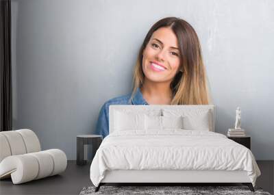 young adult woman over grey grunge wall wearing denim outfit with a happy face standing and smiling  Wall mural