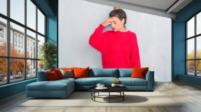 Young adult woman over grey grunge wall wearing winter outfit tired rubbing nose and eyes feeling fatigue and headache. Stress and frustration concept. Wall mural