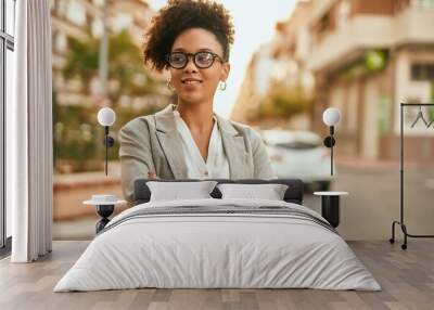 Young african american businesswoman with arms crossed standing at the city. Wall mural