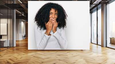 Young african american girl wearing casual clothes laughing and embarrassed giggle covering mouth with hands, gossip and scandal concept Wall mural