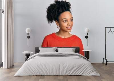 Young african american girl wearing casual clothes looking away to side with smile on face, natural expression. laughing confident. Wall mural