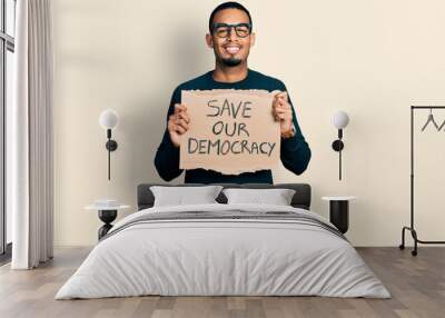 Young african american man holding save our democracy protest banner smiling with a happy and cool smile on face. showing teeth. Wall mural