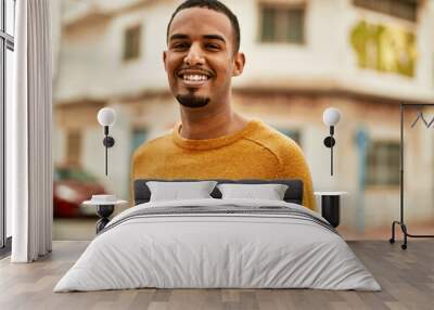 Young african american man smiling happy standing at the city. Wall mural