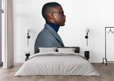 Young african american man wearing business clothes and glasses looking to side, relax profile pose with natural face and confident smile. Wall mural