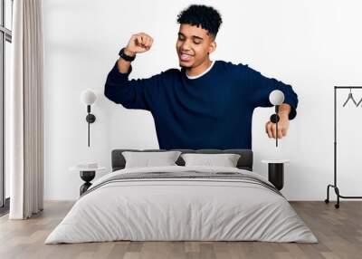 Young african american man wearing casual clothes dancing happy and cheerful, smiling moving casual and confident listening to music Wall mural