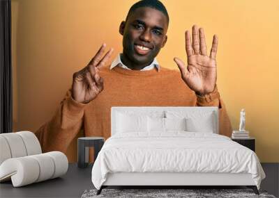 Young african american man wearing casual clothes showing and pointing up with fingers number seven while smiling confident and happy. Wall mural