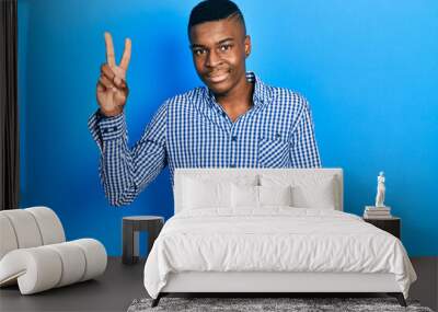 Young african american man wearing casual clothes showing and pointing up with fingers number two while smiling confident and happy. Wall mural