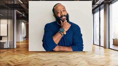 Young african american man wearing casual clothes smiling looking confident at the camera with crossed arms and hand on chin. thinking positive. Wall mural