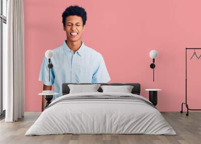 Young african american man wearing casual clothes sticking tongue out happy with funny expression. emotion concept. Wall mural