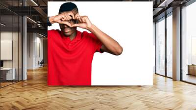 Young african american man wearing casual red t shirt doing heart shape with hand and fingers smiling looking through sign Wall mural