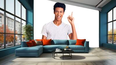 Young african american man wearing casual white t shirt pointing finger up with successful idea. exited and happy. number one. Wall mural