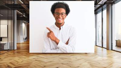 Young african american man wearing elegant shirt and glasses over isolated white background with a big smile on face, pointing with hand and finger to the side looking at the camera. Wall mural