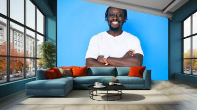 Young african american man with braids wearing casual white tshirt happy face smiling with crossed arms looking at the camera. positive person. Wall mural