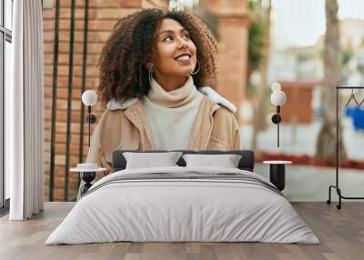 Young african american woman smiling happy standing at the city. Wall mural