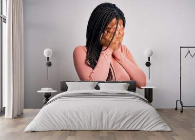 Young african american woman standing casual and cool over white isolated background with sad expression covering face with hands while crying. Depression concept. Wall mural