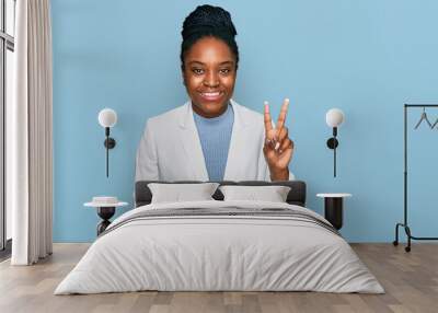 Young african american woman wearing business clothes showing and pointing up with fingers number two while smiling confident and happy. Wall mural