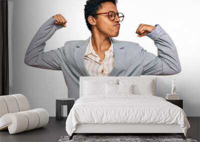 Young african american woman wearing business clothes showing arms muscles smiling proud. fitness concept. Wall mural