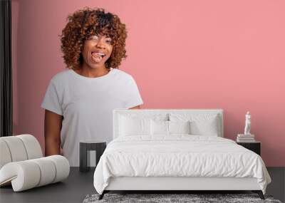 Young african american woman wearing casual white tshirt winking looking at the camera with sexy expression, cheerful and happy face. Wall mural