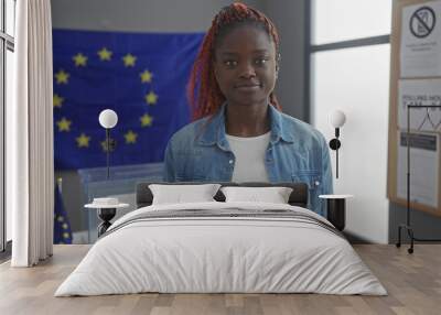 Young african woman indoors with european union flag, suggesting electoral or political theme Wall mural