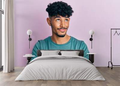 Young arab handsome man wearing casual clothes smiling looking to the side and staring away thinking. Wall mural