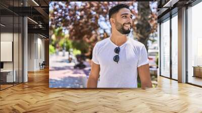 Young arab man smiling happy standing at the city. Wall mural