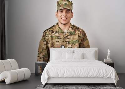 Young arab man wearing camouflage army uniform with a happy and cool smile on face. lucky person. Wall mural