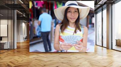 Young asian woman tourist smiling confident counting dollars at street market Wall mural