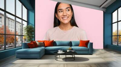 Young asian woman wearing casual clothes looking away to side with smile on face, natural expression. laughing confident. Wall mural