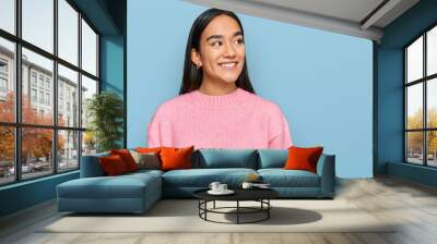 Young asian woman wearing casual winter sweater looking away to side with smile on face, natural expression. laughing confident. Wall mural