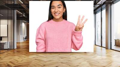 Young asian woman wearing casual winter sweater showing and pointing up with fingers number three while smiling confident and happy. Wall mural