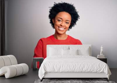 Young beautiful African American afro woman with curly hair wearing red casual sweater happy face smiling with crossed arms looking at the camera. Positive person. Wall mural