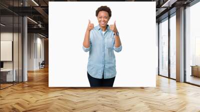 Young beautiful african american woman over isolated background success sign doing positive gesture with hand, thumbs up smiling and happy. Looking at the camera with cheerful expression Wall mural