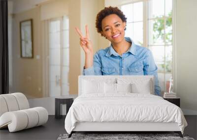 Young beautiful african american woman showing and pointing up with fingers number two while smiling confident and happy. Wall mural