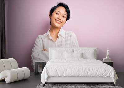 Young beautiful asian girl wearing casual shirt standing over isolated pink background happy face smiling with crossed arms looking at the camera. Positive person. Wall mural