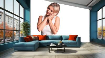 Young beautiful blonde woman wearing casual sleeveless t-shirt sleeping tired dreaming and posing with hands together while smiling with closed eyes. Wall mural