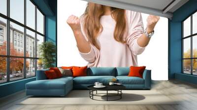 Young beautiful brunette woman wearing pink sweatshirt over isolated background celebrating surprised and amazed for success with arms raised and open eyes. Winner concept. Wall mural