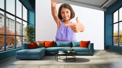 Young beautiful child girl wearing purple casual dress standing over isolated white background smiling making frame with hands and fingers with happy face. Creativity and photography concept. Wall mural