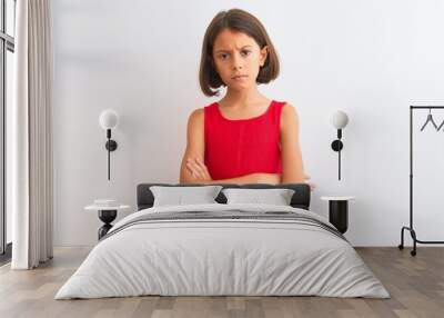 Young beautiful child girl wearing red casual dress standing over isolated white background skeptic and nervous, disapproving expression on face with crossed arms. Negative person. Wall mural