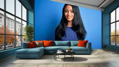 Young beautiful chinese woman wearing casual t-shirt over isolated blue background with a happy and cool smile on face. Lucky person. Wall mural